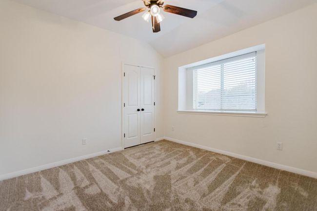 upstairs bedroom, Carpeted spare room featuring vaulted ceiling, a ceiling fan, and baseboards | Image 21