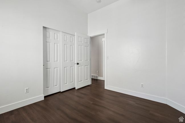Unfurnished bedroom with a closet and dark hardwood / wood-style floors | Image 21