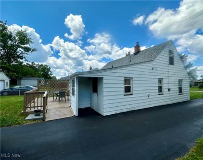 View of side of property featuring a garage, a deck, and an outdoor structure | Image 2