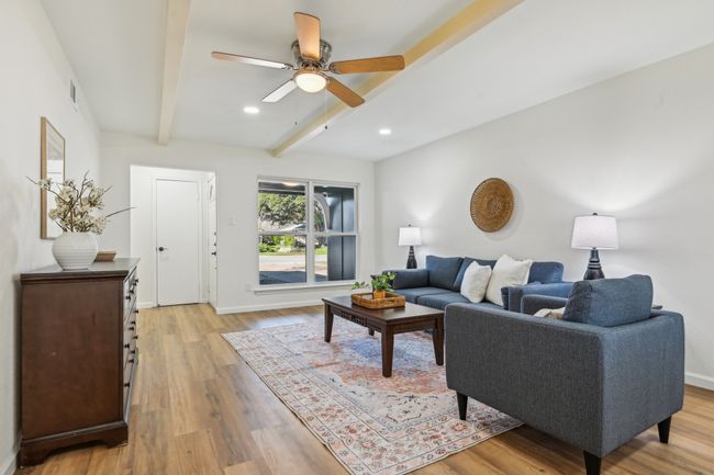 Living room with beam ceiling, light wood finished floors, a ceiling fan, recessed lighting, and baseboards | Image 5