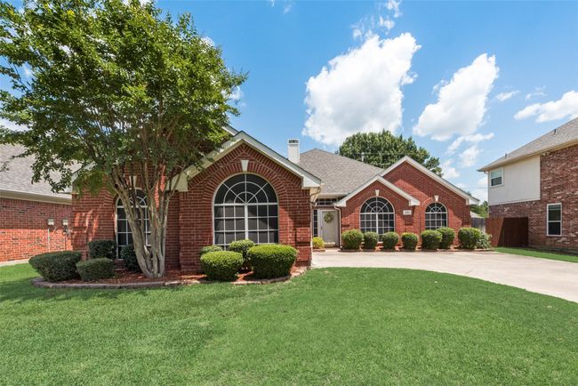 View of front facade featuring brick siding, driveway, a chimney, and roof with shingles | Image 4