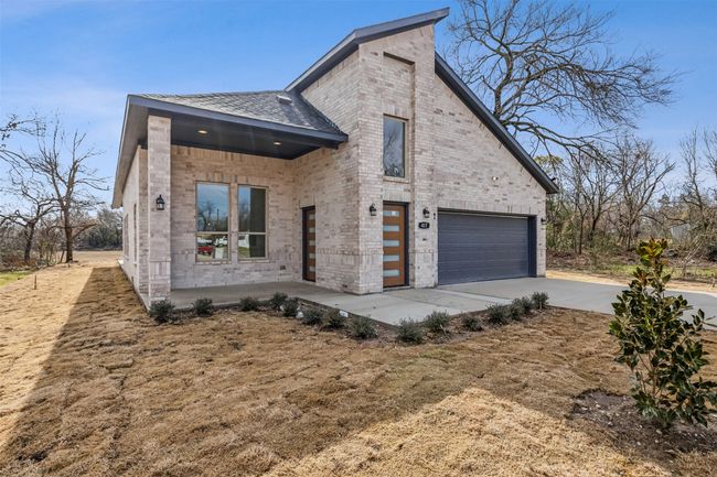 View of front of house featuring brick siding, concrete driveway, and an attached garage | Image 5