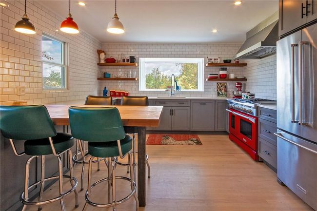 Kitchen featuring pendant lighting, sink, high end appliances, butcher block countertops | Image 9