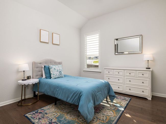 Bedroom featuring dark wood-style flooring, baseboards, and vaulted ceiling | Image 12