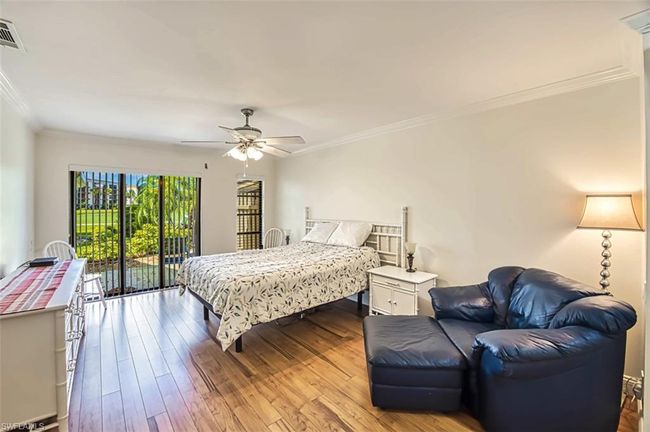 Bedroom with wood finished floors, a ceiling fan, ornamental molding, and access to exterior | Image 27
