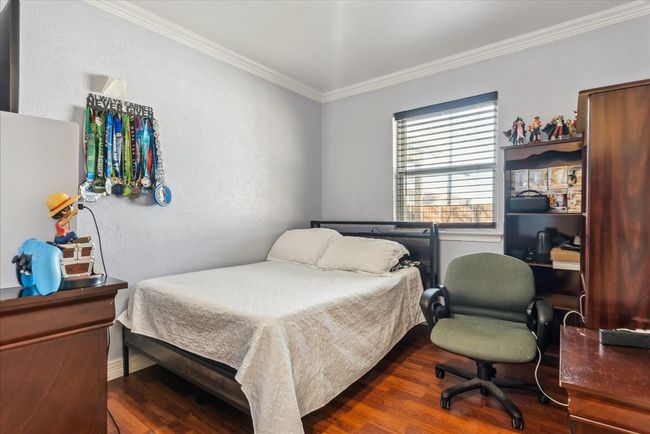 Bedroom with ornamental molding and dark wood-type flooring | Image 12