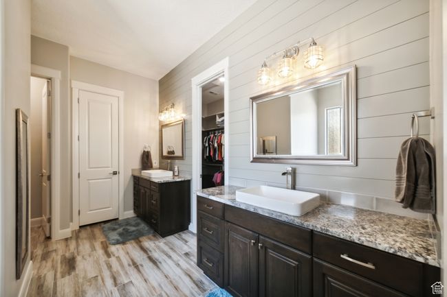 Full bathroom featuring two vanities, wood finished floors, a sink, and wood walls | Image 17
