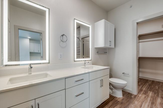 Bathroom featuring double vanity, toilet, wood finished floors, and a sink | Image 15