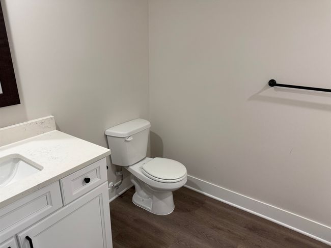 Half bathroom with baseboards, wood finished floors, vanity, and toilet | Image 16