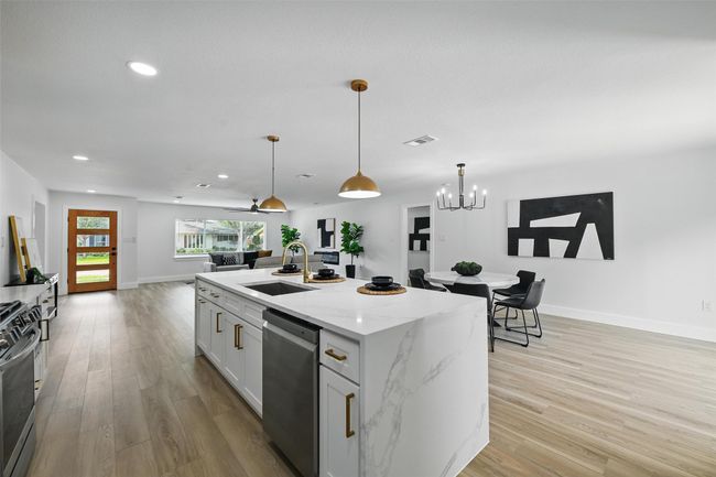Kitchen featuring appliances with stainless steel finishes, a sink, light wood-style floors, recessed lighting, and decorative light fixtures | Image 10
