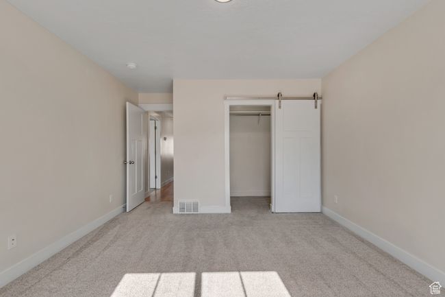 Unfurnished bedroom with carpet flooring and a closet | Image 21