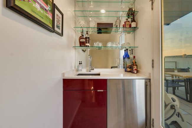 Bar featuring sink and stainless steel fridge | Image 32