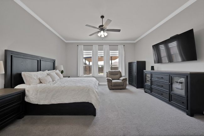 Bedroom featuring ornamental molding, light colored carpet, and a ceiling fan | Image 22
