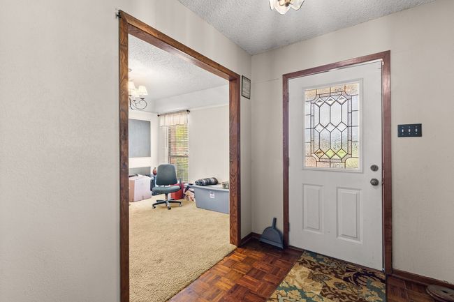 Foyer featuring dark colored carpet, baseboards, and a textured ceiling | Image 9