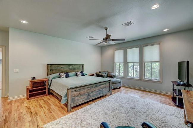 Bedroom with recessed lighting, wood finished floors, visible vents, baseboards, and ceiling fan | Image 23
