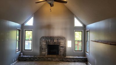 Unfurnished living room featuring ceiling fan, a fireplace, and high vaulted ceiling | Image 2