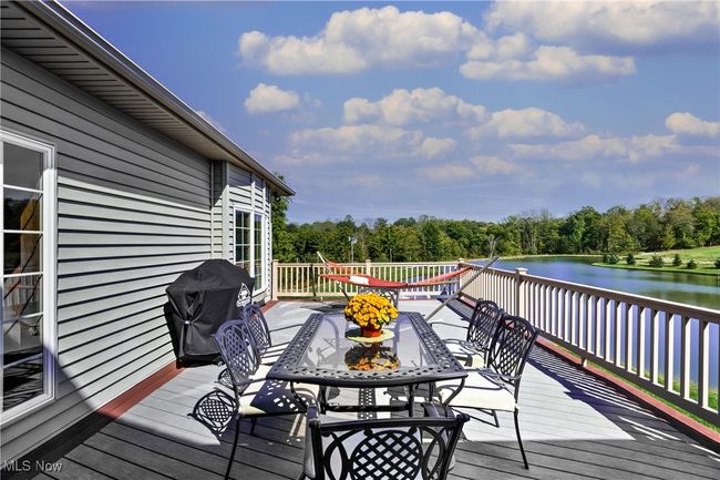Wooden deck with outdoor dining space, area for grilling, and a water view | Image 14