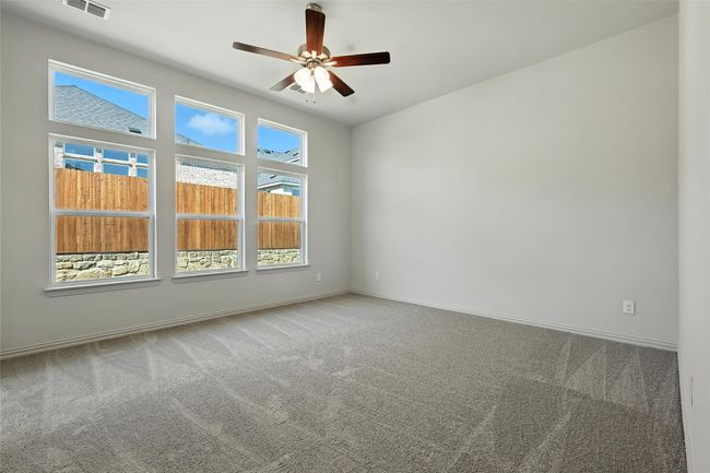 Carpeted empty room with ceiling fan and baseboards | Image 17