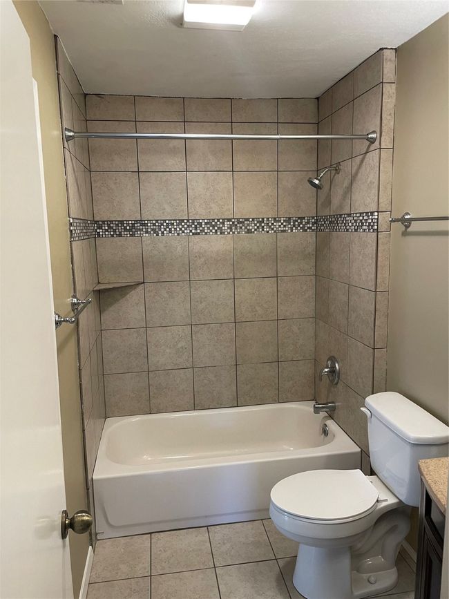 Full bathroom featuring toilet, tile patterned flooring, tiled shower / bath, and vanity | Image 18