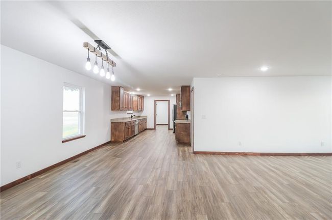 Unfurnished living room with light hardwood / wood-style floors and sink | Image 5