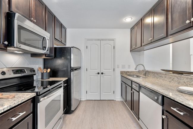 Stainless steel appliances complement the sleek granite countertops, providing a modern and functional cooking space. | Image 14