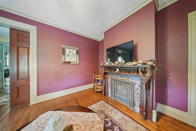 Living room with a fireplace, crown molding, baseboards, and hardwood / wood-style floors | Image 16