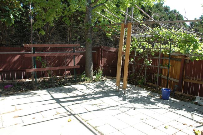 Fenced backyard with a patio area | Image 11