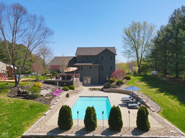 outdoor pool featuring a patio area, a lawn, a playground, and a deck | Image 5
