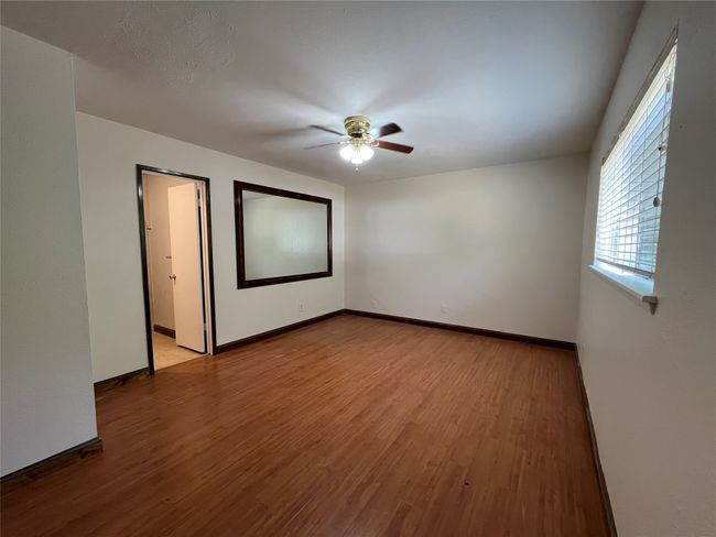 Empty room featuring a ceiling fan, wood finished floors, and baseboards | Image 10