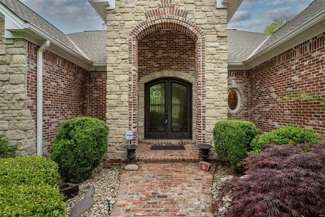 Property entrance with french doors, brick siding, and a shingled roof | Image 4