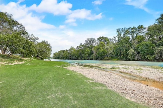 Surrounding community featuring a water view, a wooded view, and a lawn | Image 23