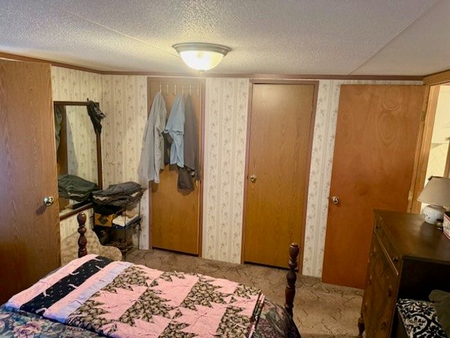 Bedroom featuring wallpapered walls, carpet floors, and a textured ceiling | Image 23