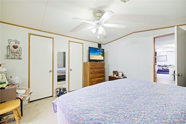 Primary Bedroom with light colored carpet, ornamental molding, two closets, and a ceiling fan | Image 9