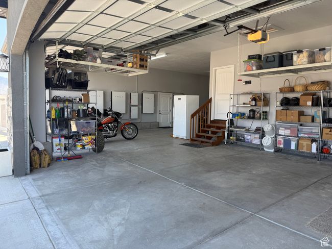 Garage featuring freestanding refrigerator and a garage door opener | Image 97