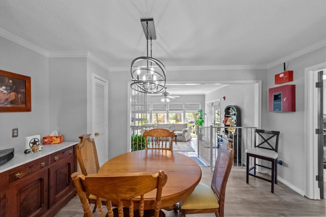 Dining room featuring baseboards, ornamental molding, ceiling fan with notable chandelier, and light wood finished floors | Image 16