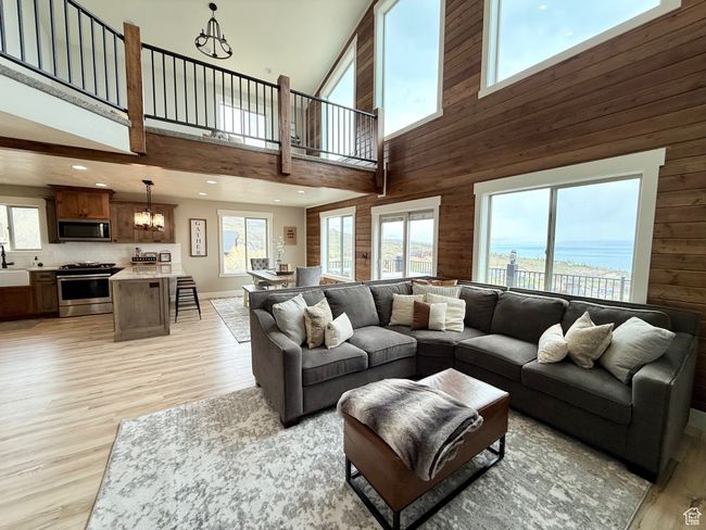 Living area with a high ceiling, a notable chandelier, and a healthy amount of sunlight | Image 13