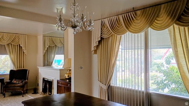 Carpeted dining room featuring a fireplace with flush hearth and a chandelier | Image 11