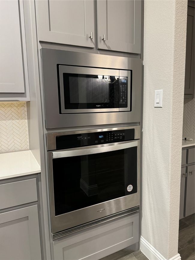 Details with gray cabinets, oven, and decorative backsplash | Image 12