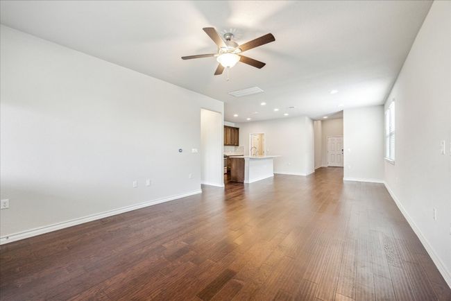 Unfurnished living room featuring dark wood-style flooring, a sink, a ceiling fan, baseboards, and recessed lighting | Image 6