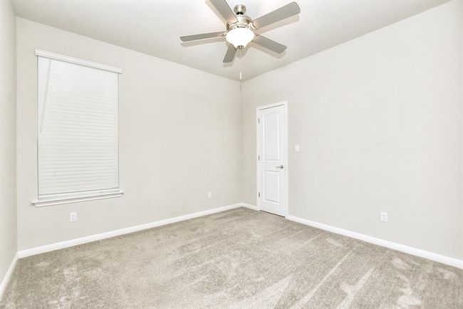 Empty room featuring carpet floors, ceiling fan, and a smoke detector | Image 19