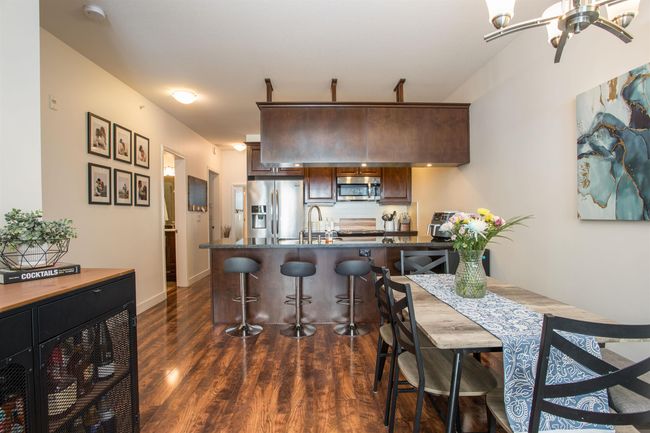 Dining area with dark wood-type flooring, a ceiling fan, and baseboards | Image 9