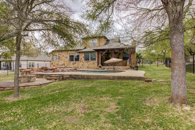 Rear view of house with pool, a fire pit, and a patio area | Image 33