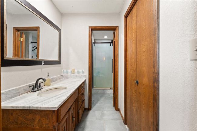 Bathroom featuring a shower stall, vanity, and tile patterned floors | Image 22