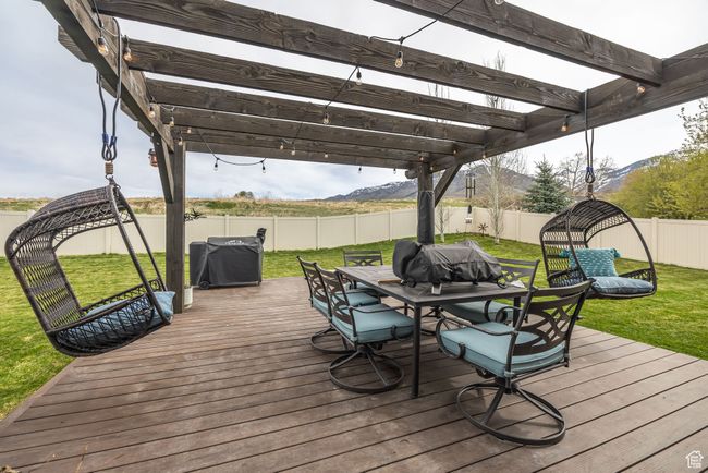 Deck with pergola featuring outdoor dining area, a mountain view, a fenced backyard, and a lawn | Image 34