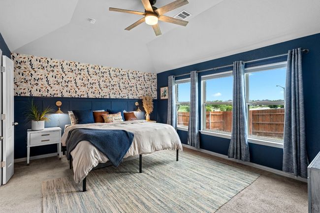 Bedroom with vaulted ceiling, light carpet, ceiling fan, a wainscoted wall, and wallpapered walls | Image 20
