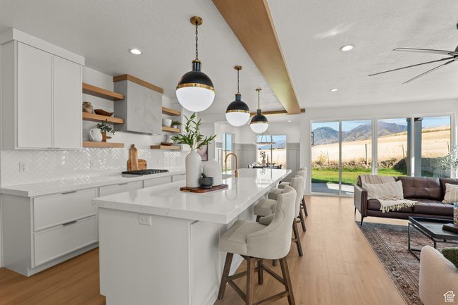 Kitchen featuring white cabinets, open shelves, a mountain view, pendant lighting, and a breakfast bar | Image 17