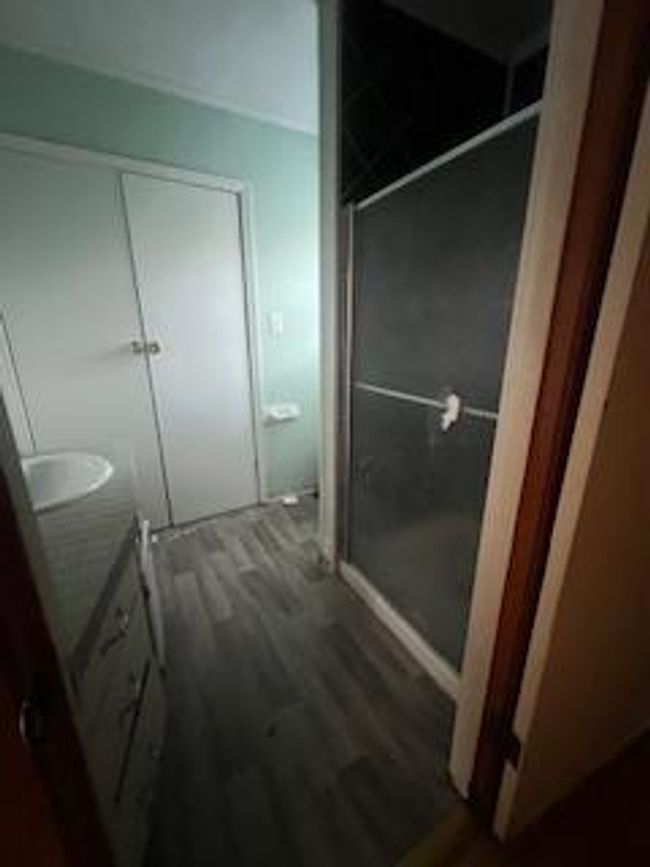 Bathroom with vanity, wood finished floors, and a stall shower | Image 8