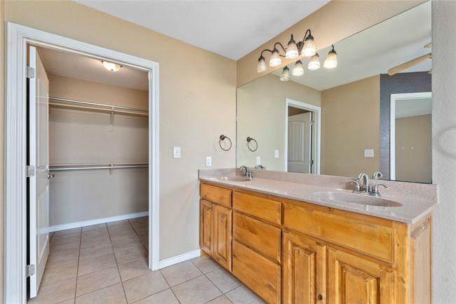 Full bathroom with tile patterned floors, double vanity, and a walk in closet | Image 13