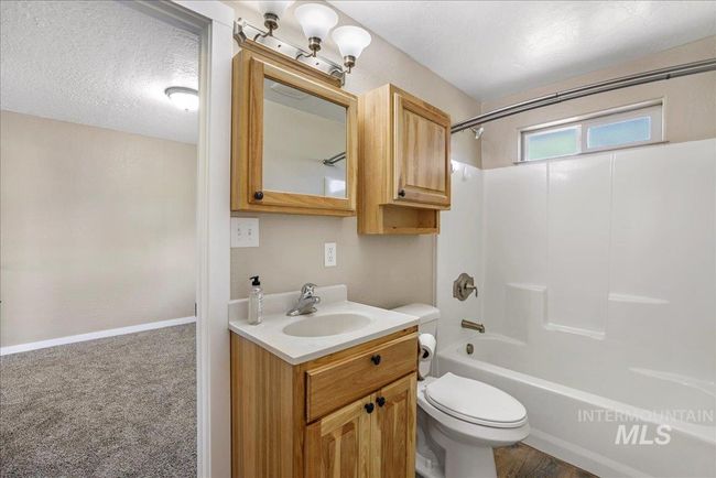 Bathroom with vanity, shower / washtub combination, and a textured ceiling | Image 16