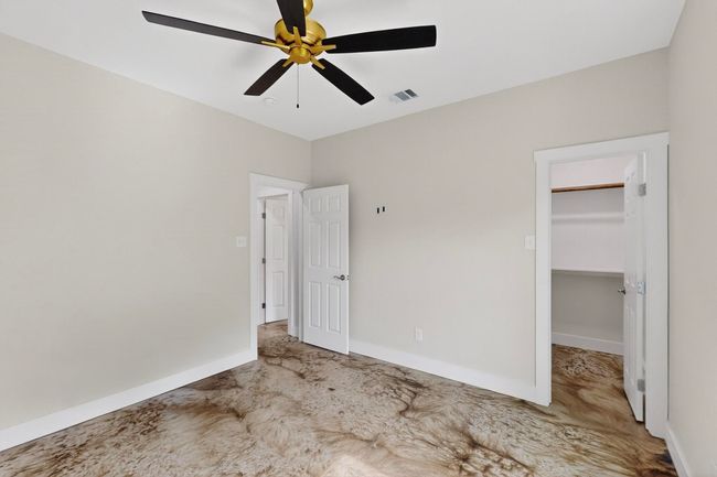 Unfurnished bedroom with a spacious closet and ceiling fan | Image 40